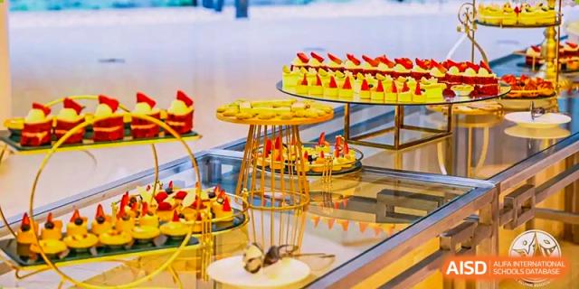 A display of various colorful and decorative pastries and desserts on a buffet table at the International Curriculum Center of RDFZ.