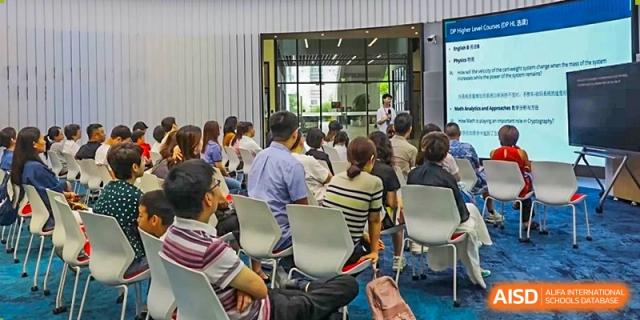 A group of students from ISA Science City International School is seated in a hall during a presentation.