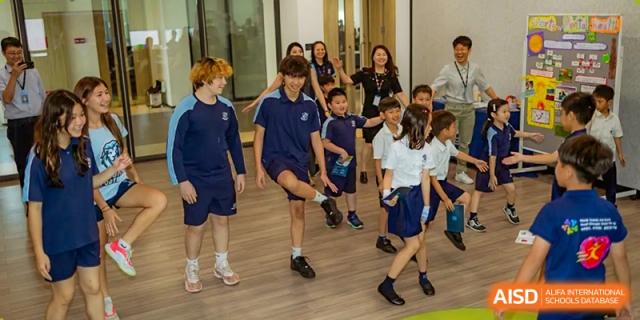 Two students from ISA Science City International School are running in a race on a sports field.