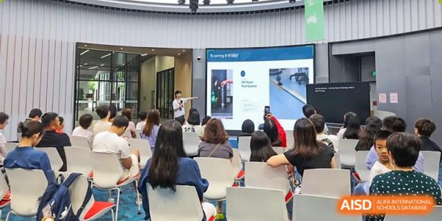 A female student from ISA Science City International School, wearing a school uniform, is playing an acoustic guitar.