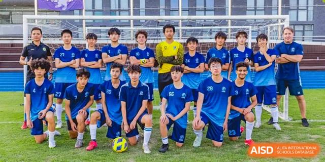 A group of male students from ISA Science City International School, wearing blue jerseys, are posing with a soccer ball.
