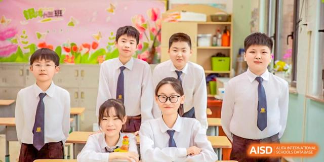 Four high school students in white shirts and ties posing together against a pink and green background at Maple Leaf Foreign Nationals School-Yiwu.