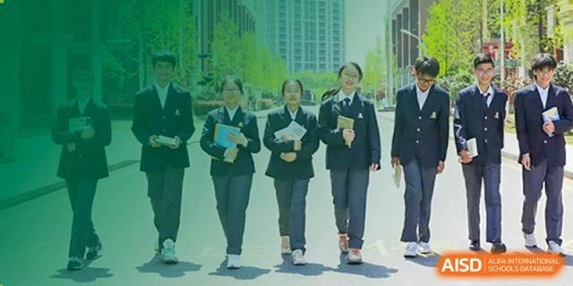 A row of female students in school uniforms walking together against a background featuring an architectural graphic at Maple Leaf Foreign Nationals School-Yiwu.