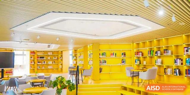 A brightly lit library or common area at NANJING THOMAS SCHOOL with yellow bookshelves.