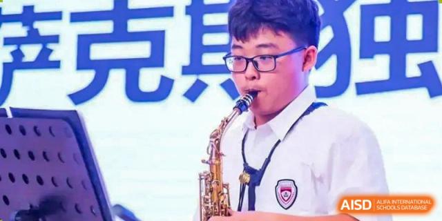A NANJING THOMAS SCHOOL student is playing a saxophone during a performance.