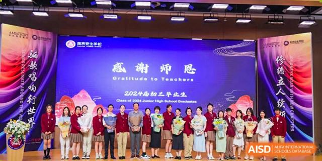 NANJING THOMAS SCHOOL students and staff standing on a stage with a banner that reads "Gratitude to Teachers".