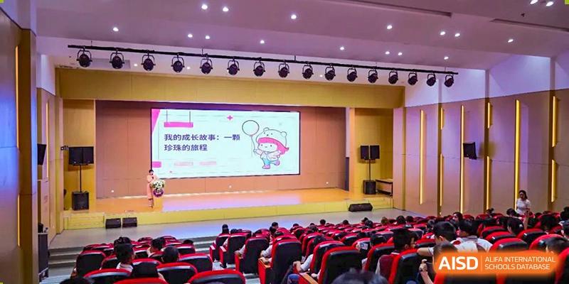 NANJING THOMAS SCHOOL students sitting in an auditorium and watching a presentation on a screen.
