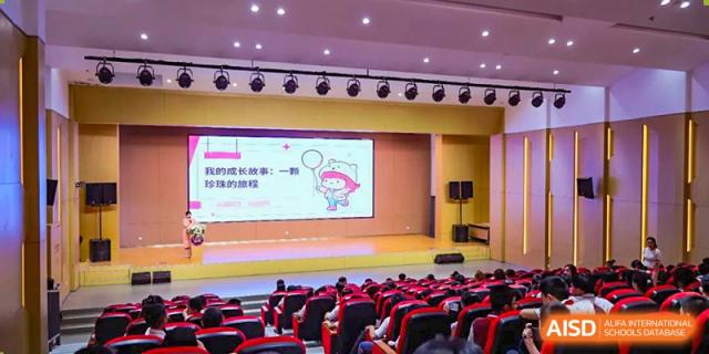 NANJING THOMAS SCHOOL students sitting in an auditorium and watching a presentation on a screen.