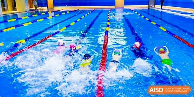 NANJING THOMAS SCHOOL students are swimming laps in a competition pool.