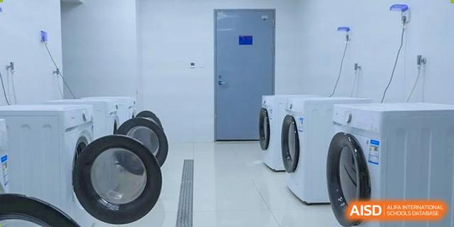 Washing machines and dryers are in a clean laundry room at NANJING THOMAS SCHOOL.