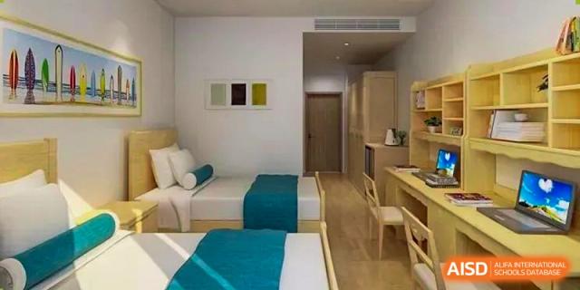 A clean and modern dormitory room with two single beds at NANJING THOMAS SCHOOL.