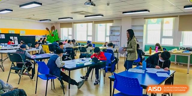Students working on an assignment in a busy classroom at the Qingdao Amerasia International School.