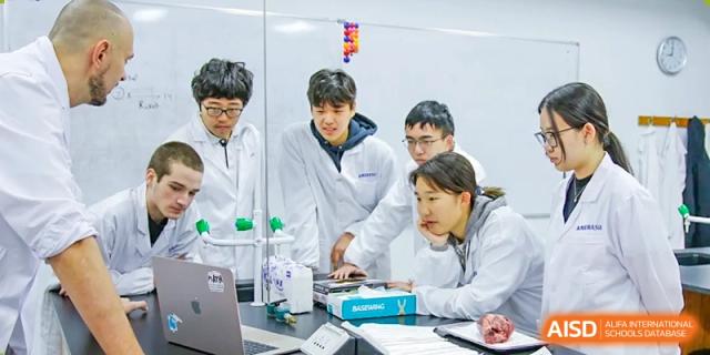 A group of students in lab coats conducting a science experiment in a lab at the Qingdao Amerasia International School.