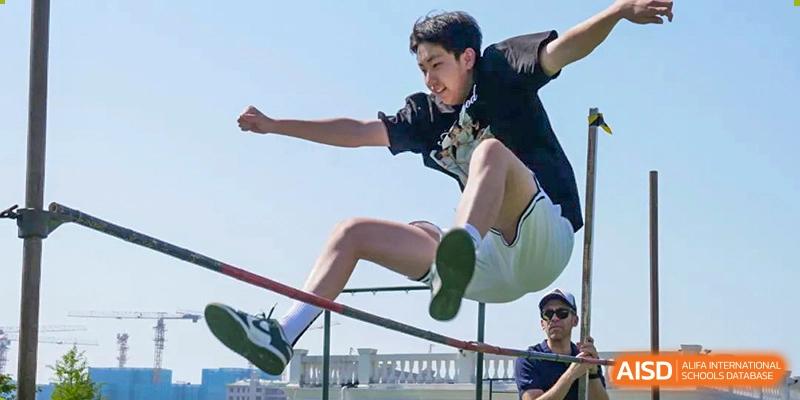 A male student clearing the bar during a high jump event at a sports competition at the Qingdao Amerasia International School.