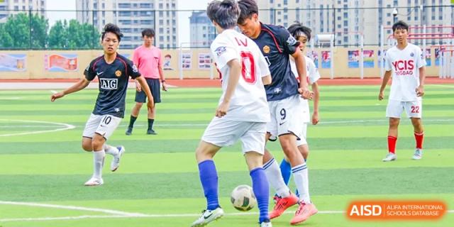 Students playing soccer on a turf field during a match at the Qingdao Amerasia International School.