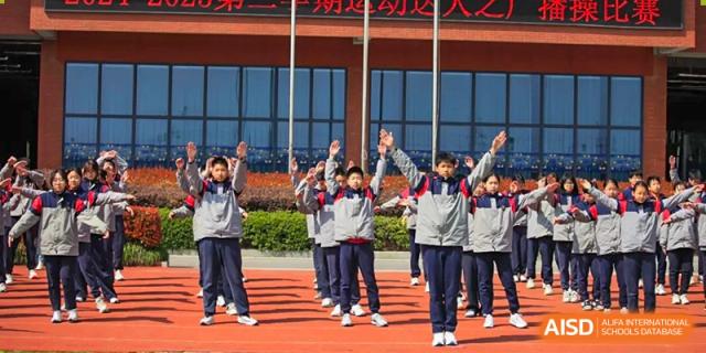 Students from Rugao International Academy BFSU waving on a playground.