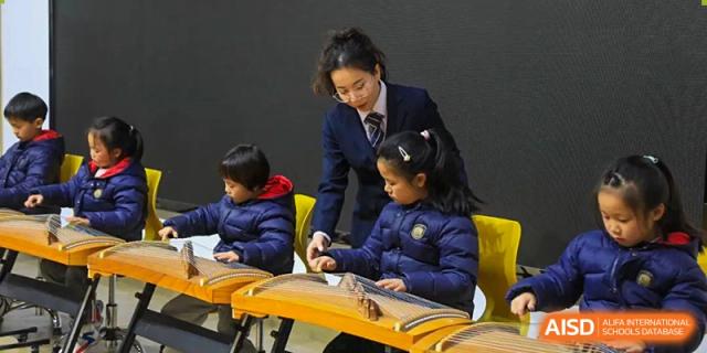 A teacher from Rugao International Academy BFSU helping students with their work.