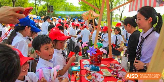 Students from Rugao International Academy BFSU selling handicrafts at a school fair.