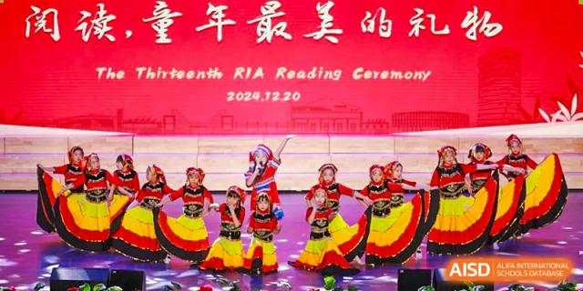 Students from Rugao International Academy BFSU performing a traditional dance on a stage.