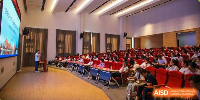 A group of students and teachers from Rugao International Academy BFSU attending an indoor school event.