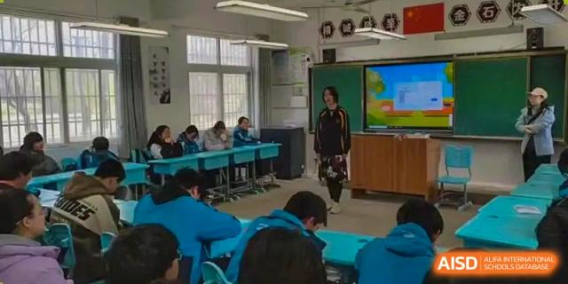 A student presenting at the front of a classroom with other students seated at tables at Shanghai Wenlai International School.