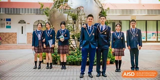 Three students in formal school uniforms posing outdoors in a garden setting, with two boys and one girl at Shanghai Wenlai International School.