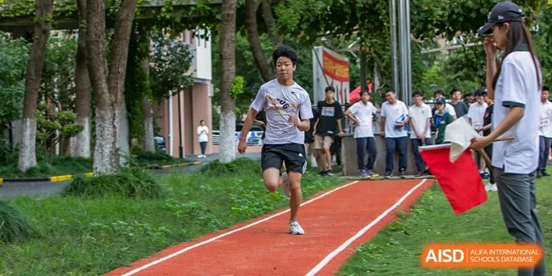 A male student running a sprint race on a red track during a sports event at Shanghai Wenlai International School.