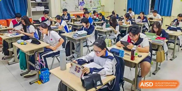 Students at Shenzhen (Nanshan) Concord College of Sino-Canada working independently at their desks on laptops and tablets.