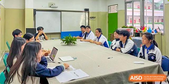 Students and teachers at Shenzhen (Nanshan) Concord College of Sino-Canada in a conference room with a long table, having a discussion.