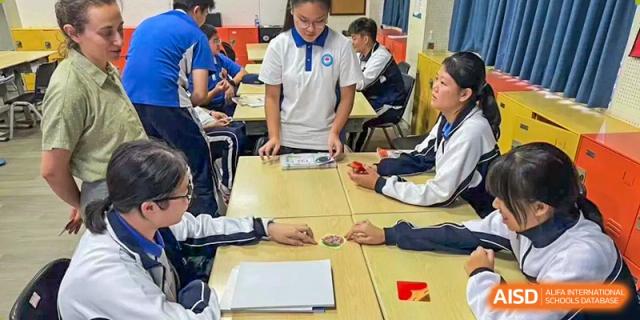 A group of students at Shenzhen (Nanshan) Concord College of Sino-Canada focused on a hands-on activity with a teacher.
