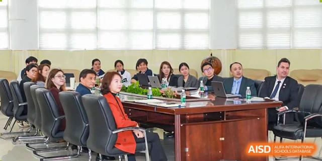 A teacher at Shenzhen (Nanshan) Concord College of Sino-Canada leading a discussion with a group of students around a table.