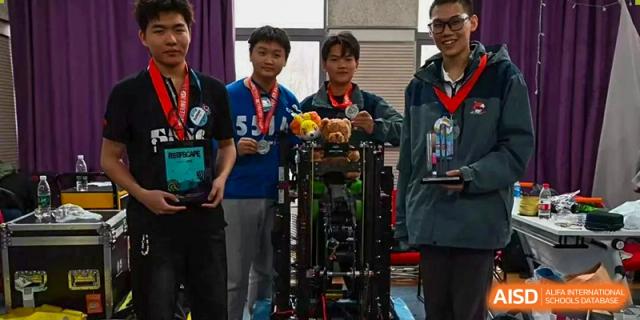 Two students and a teacher at Shenzhen (Nanshan) Concord College of Sino-Canada posing with a robotic model.