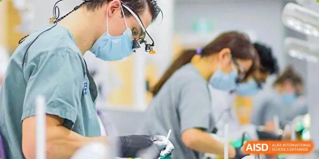 A close-up of a person in a lab coat at Shenzhen (Nanshan) Concord College of Sino-Canada holding a medical tool or instrument.