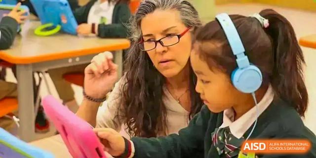 A female teacher at Sias International School intently guides a young student on an activity.