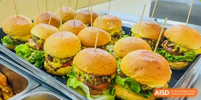 Close-up of several mini cheeseburgers on a lunch tray at Sias International School's cafeteria.