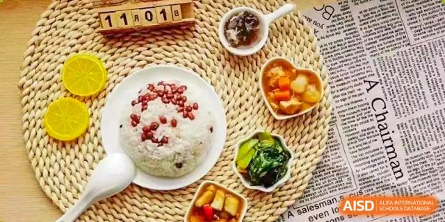 An overhead shot of a traditional Chinese meal including rice topped with red beans, side dishes, and soup, possibly served at Sias International School.