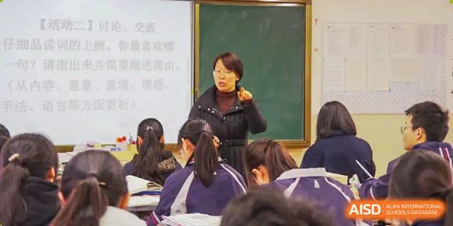 A female teacher is standing and speaking to a classroom of students at SUZHOU INTERNATIONAL FOREIGN LANGUAGE SCHOOL.