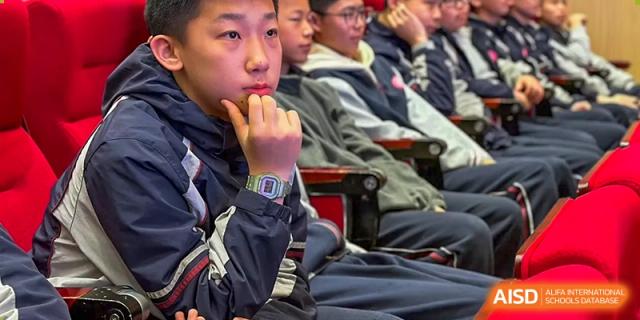 A group of teenage students, some wearing glasses, listening attentively in a classroom at SUZHOU INTERNATIONAL FOREIGN LANGUAGE SCHOOL.