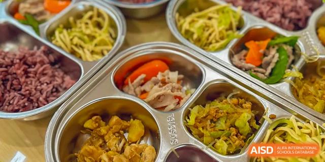 Another view of a metal school lunch tray with various food items at SUZHOU INTERNATIONAL FOREIGN LANGUAGE SCHOOL.