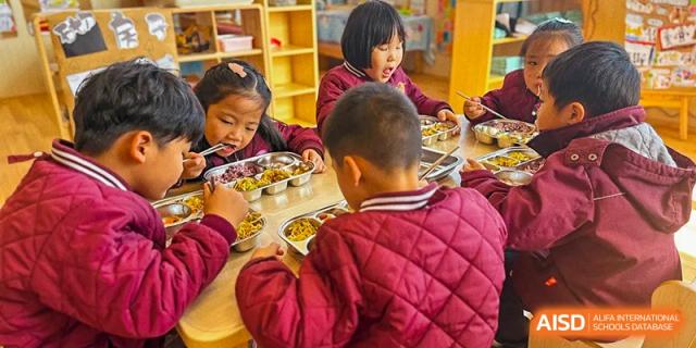 Two young students are sitting at a table eating their meal at SUZHOU INTERNATIONAL FOREIGN LANGUAGE SCHOOL.
