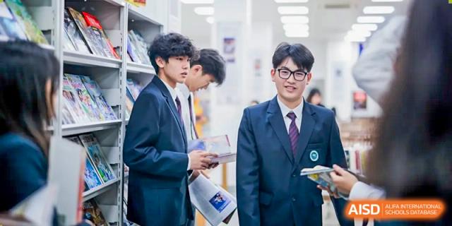Students in suits at The Experimental School Affiliated to Nanjing Normal University talking in a hallway.
