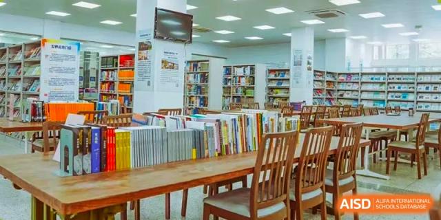 An empty library at The Experimental School Affiliated to Nanjing Normal University with wooden tables and bookshelves.