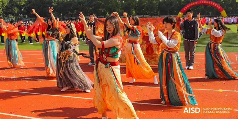 Students from The Experimental School Affiliated to Nanjing Normal University are performing a traditional dance on a stage.