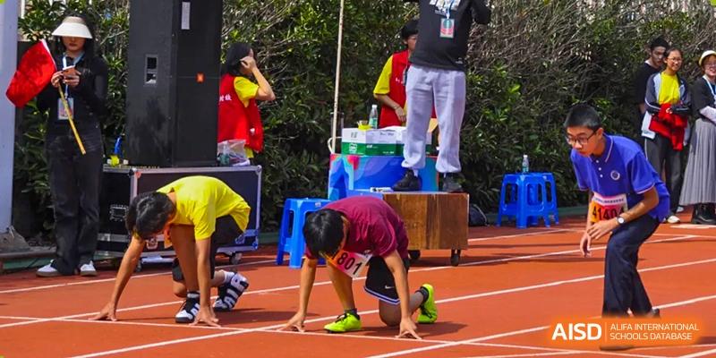 A student from The Experimental School Affiliated to Nanjing Normal University is crouching on a running track, possibly at the starting line of a race.