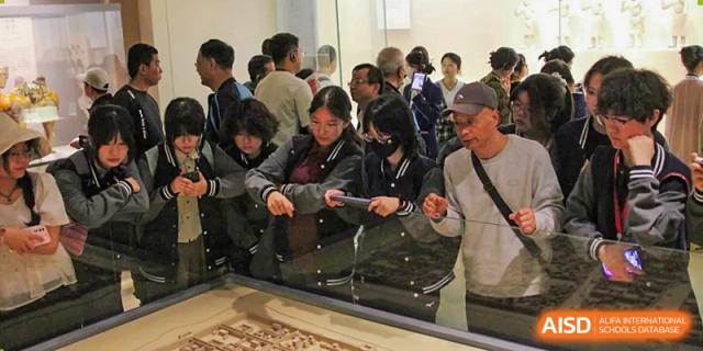 A crowd of students from The Experimental School Affiliated to Nanjing Normal University are gathered to watch an event.