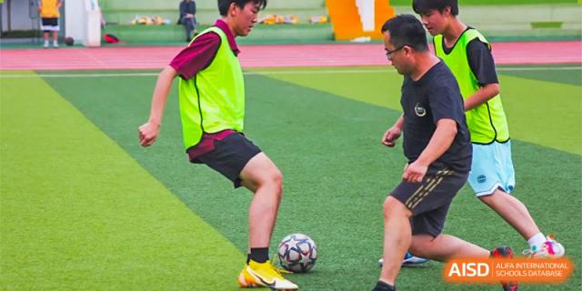 A student from The Experimental School Affiliated to Nanjing Normal University is dribbling a soccer ball.