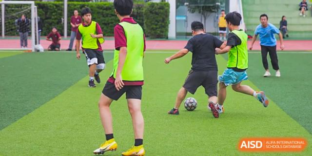 Students from The Experimental School Affiliated to Nanjing Normal University are playing soccer on a grassy field.