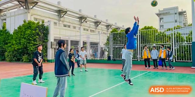 Students from The Experimental School Affiliated to Nanjing Normal University are playing a game on a green sports court.
