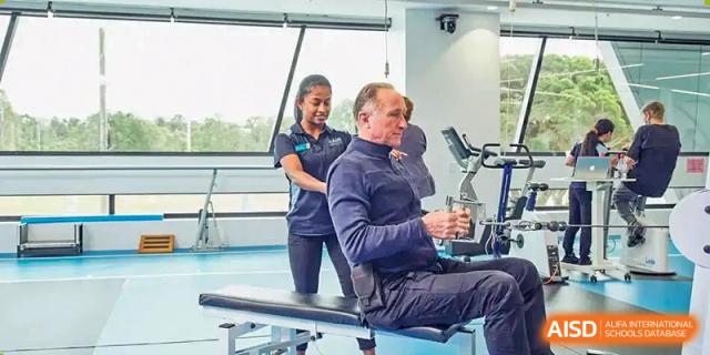 A person at The Experimental School Affiliated to Nanjing Normal University being assisted with a gym machine.