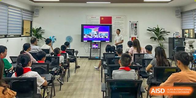 Students watching a presentation on a large screen in a classroom at Weiming School Chengdu Qingbaijiang.